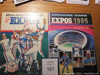 Photo showing two Montreal Expos souvenir yearbooks from 1982 and 1985 with colorful covers and team photos.