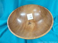 Top inside view showing natural wood grain, stains, and part of a crack on the interior surface of the large wooden bowl.