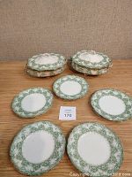 Two covered vegetable dishes and five plates with green Fern pattern floral design on white ceramic surface. Pieces show vintage signs indicating antique tableware.