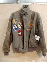 Full view of military style jacket with patches and quilted sleeves