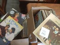 Two cardboard boxes filled with assorted vinyl LP albums, showing visible album covers of various artists.