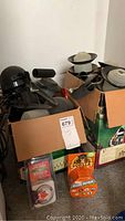 Photo showing multiple black outdoor garden lights in a cardboard box with packaging for Gorilla clear repair tape and a 24-hour lamp/appliance timer.