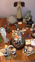 Top view of 15 figurines exhibiting various religious and seasonal themes including children with pumpkins and angels.