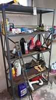 Full view of metal shelf with various items including tools, cleaning products, Pyrex, and other household items.