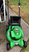 Front view of green Lawn Boy lawnmower with grass catcher and intact handlebar assembly