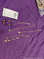 Four necklaces laid on purple background