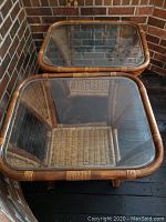 Pair of bent wood and wicker side tables with square glass tops viewed from above, showing wicker seats and wood frames.
