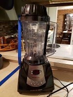 Front view of the blender showing pitcher and base unit on a kitchen counter with control panel visible.