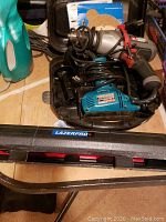 Image showing Porter Cable drill and Makita disc sander in hard case with Lazerpro level case in front