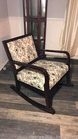 Front side view of wooden rocking chair with patterned cushion upholstery