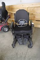 Front view of power wheelchair showing seat, backrest, armrests, footplate