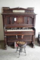 Full front view of antique pedal organ and piano stool