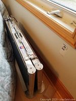 Folded ramp leaning against wall under window.