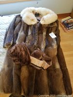 Full view of muskrat fur coat with cream-colored collar and additional fur piece on top showing overall condition.