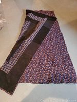 Dark floral quilt with checkered border laid out flat on floor