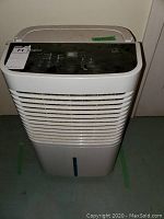 Front view of the white Whirlpool dehumidifier showing air intake vents and water level indicator.