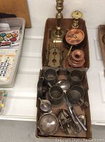 Photo showing the pewter mugs, plated silver items including teapot, bowls, scoop, and trays alongside other small metal items.
