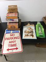 Metal signs and stack of assorted cigar boxes on a table