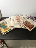 Wide view of entire lot showing stacks of old advertising ads and litho prints in plastic covers.