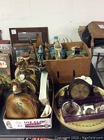 Wide shot showing 15 James Beam bourbon bottles arranged in two wooden trays alongside a decorative ceramic tray and miscellaneous items including a clock and trinket container.