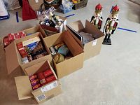 Overview of multiple boxes with various Christmas holiday items including nutcracker figurines and boxes of lights