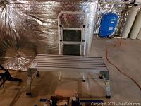 Work platform bench and folded step ladder in storage space, showing size and condition