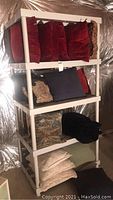 Shelf with various decorative pillows including red velvet and navy patterned pillows