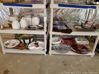 Full view of multiple platters, canisters, bowls, glass casserole dishes, utensils, and pot holders arranged on shelving units.