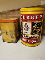 Photo of the two vintage tins side by side, showing their relative size and front designs.