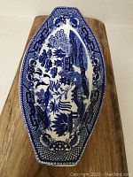 Top view of blue and white elongated octagonal ceramic dish showing detailed scenic landscape in cobalt blue.