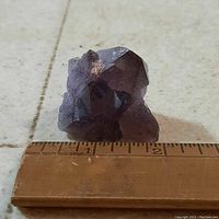 Amethyst crystal cluster viewed from front showing its size against a ruler.