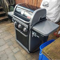 Side view of the Coleman Revolution BBQ grill showing body, control knobs, and side shelf.