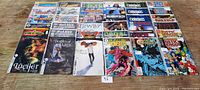 Photo showing all comics laid out on a wooden surface, multiple titles visible with numbering and colorful covers.