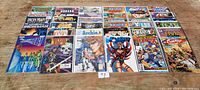 Full view of all 26 comic books laid flat on wooden surface