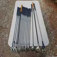 Photo showing all left-handed golf clubs laid out, including irons, woods, and putter.