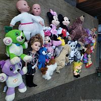 Wide layout of mixed used plush toys and dolls showing wear