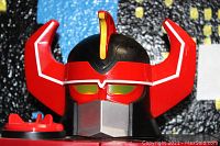 Close-up of the Megazord head showing red horns, glowing eyes, and face details.