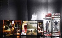 Full lot overview showing DVDs and action figures in packaging against black background