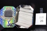 Metal Pokemon trading card collector's tin featuring artwork of Xerneas, filled with a large stack of cards.