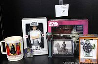 Photo showing the Leia Organa figurine in box, Return of the Jedi coffee cup, pewter key chain, Star Wars trading card, Resistance X-Wing in box, Storm Trooper Pez dispenser, and Storm Trooper watch in orange box.