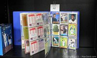 Front view of blue binder open to reveal 9-pocket sheets with assorted cards