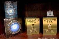 Full lot including outer box with Stargate portal design, two gold inner boxes, and the booklet upright displayed.