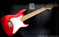 Front view of Burswood electric guitar showing metallic red body, white pickguard, 5 strings, maple neck and fretboard.