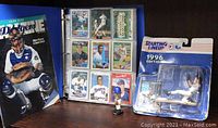 Blue binder filled with 198 baseball trading cards, Dodgers Magazine with Mike Piazza on the cover, 1996 Starting Lineup Vinny Castilla figure and trading card, and Texas Rangers A. Rodriguez mini bobblehead.