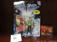 Playmates Captain James T. Kirk action figure in original blister pack with collector card beside it on a table.