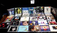 Front view of 50 assorted CDs arranged in rows showing artist and album titles
