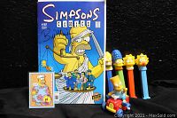 Full lot of Simpsons collectibles including the autographed Simpsons Comics #107, PEZ dispensers, and Bart car figurine visible together.