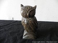 Front view of carved wooden owl sculpture showing detailed head and feather carvings.