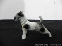 Side view of the porcelain Scottish Terrier dog figurine showing texture and color patterns.
