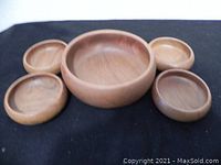 Set of five teak wood bowls displayed from above showing arrangement and sizes.